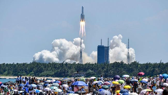 Onlookers watch the launch of a rocket transporting China’s second module for its Tiangong space station. Picture: AFP