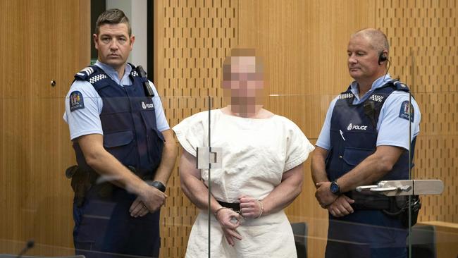 Brenton Tarrant makes a hand sign to the camera during his appearance in the Christchurch District Court on Saturday.