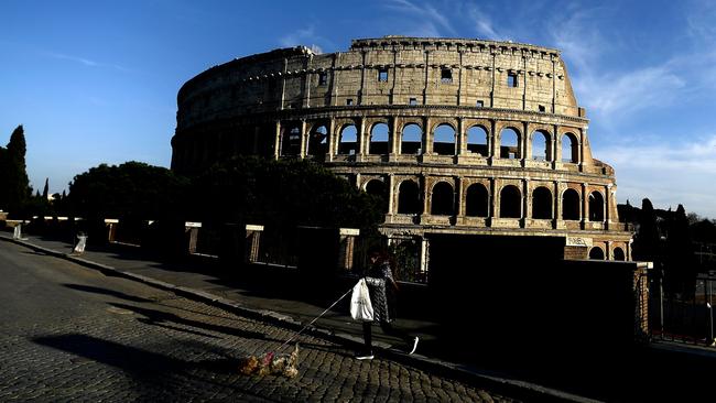 A woman walks with her dog by the Colosseum in Rome, during the country's lockdown aimed at curbing the spread of the COVID-19 infection. Picture: Filippo Monteforte/AFP