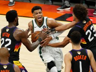 PHOENIX, ARIZONA - JULY 06: Giannis Antetokounmpo #34 of the Milwaukee Bucks is pressured by Deandre Ayton #22 and Cameron Johnson #23 of the Phoenix Suns during the second half in Game One of the NBA Finals at Phoenix Suns Arena on July 06, 2021 in Phoenix, Arizona. NOTE TO USER: User expressly acknowledges and agrees that, by downloading and or using this photograph, User is consenting to the terms and conditions of the Getty Images License Agreement. (Photo by Chris Coduto/Getty Images)