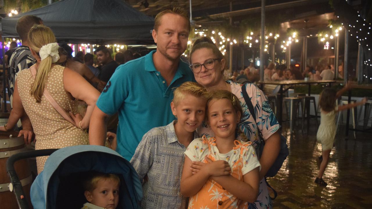 Sean and Sarah Hayward sheltered from the rain with their children Theodore (3), Logan (10) and Lillian (8). Picture: Laura Thomas