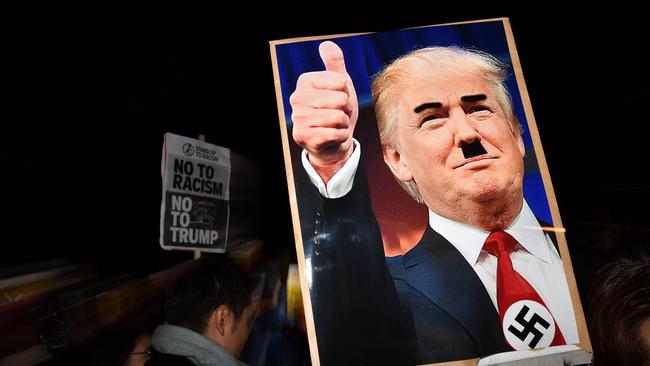 Not new charges … A demonstrator’s placard at a protest in 2016 shows a picture of Republican presidential candidate Donald Trump modified to add a swastika and an Adolf Hitler-style moustache. Picture: Ben Stansall/AFP