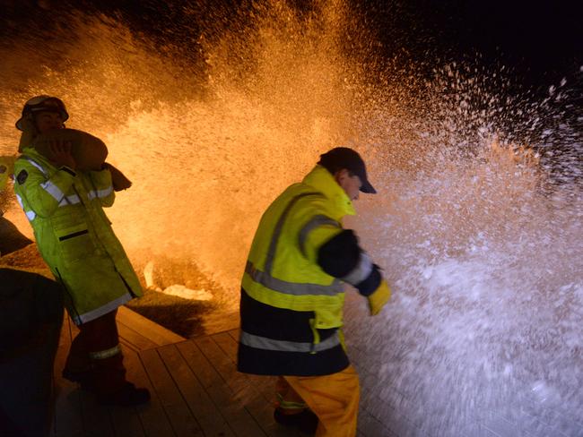 Emergency services work in trying conditions as peak tide hits. Picture: Jeremy Piper