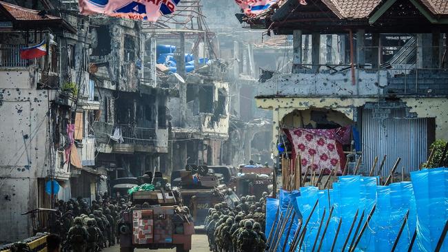 Philippine Marines move past buildings damaged in the conflict with IS militants in Marawi in 2017. Picture: AFP Photo / Ferdinandh Cabrera