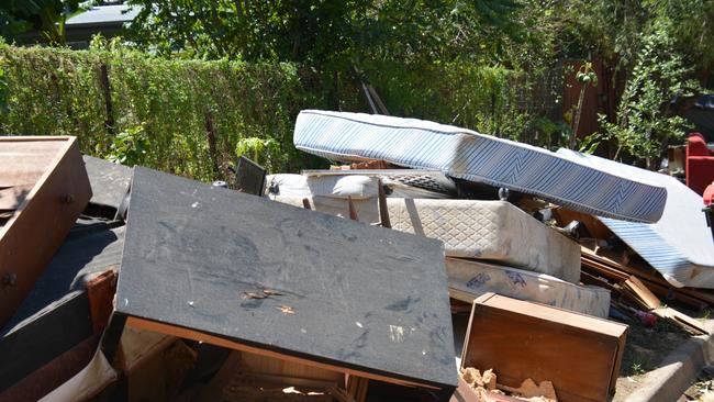 Streets in Machans Beach are piled high with wrecked furniture, whitegoods, mattresses and household contents as residents sort through what little is left. Picture: Bronwyn Farr