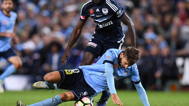 Milos Ninkovic of Sydney is tackled by Jason Geria