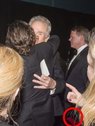 Brian Callinan, right, holding two Oscars envelopes ... and a phone. Picture: Andrew H. Walker/REX/Shutterstock