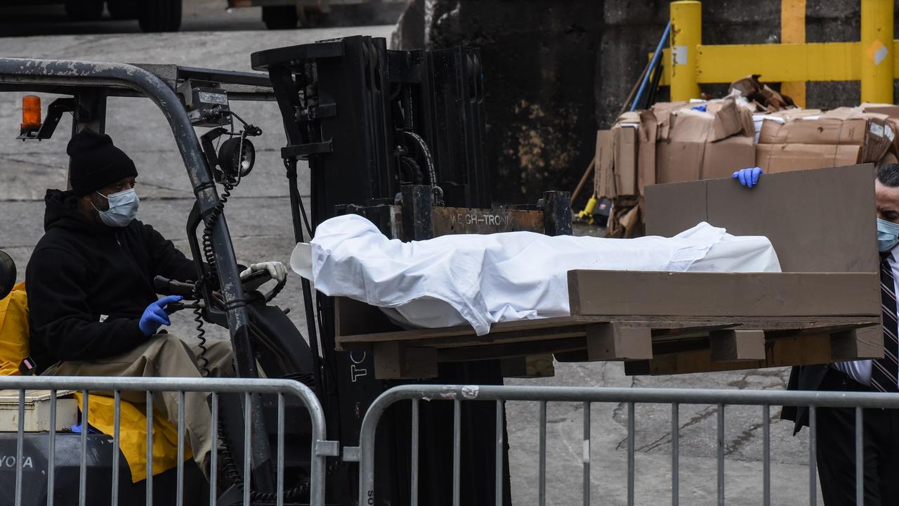 A body is moved by forklift outside Brooklyn Hospital in New York where there has been a surge in coronavirus deaths. Picture: Stephanie Keith/Getty Images/AFP