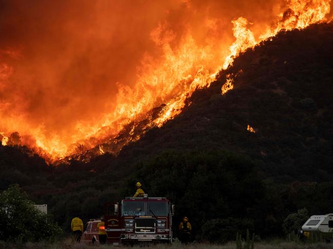 Firefighters watch as flames approach a retardant line near a residential community during the Apple fire in Banning, California. Picture: AFP