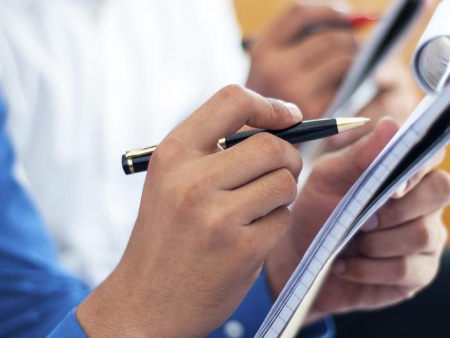 Business people writing on notepad. Generic shot of reporter. Picture: ThinkStock