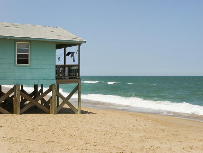 House built directly on the beach, with laundry drying on the clothesline. "Ocean View", #10392