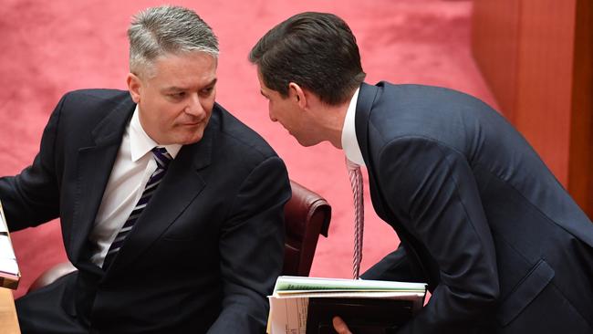 Minister for Finance Mathias Cormann and Minister for Trade Simon Birmingham during the debate on Senator Pauline Hanson's "OK To Be White" motion in the Senate chamber at Parliament House this week. Picture: AAP Image/Mick Tsikas