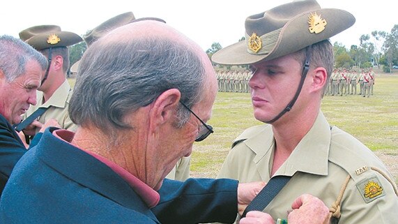 Dave Garratt being presented a medal.