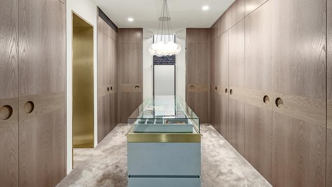 A huge walk-in wardrobe with display case.