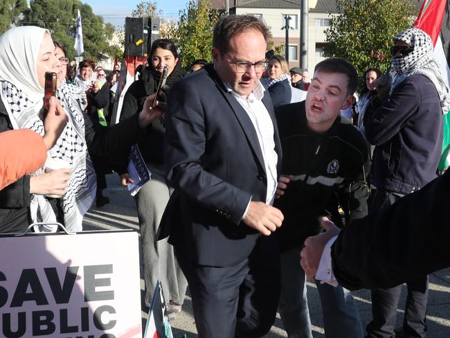 A delegate is pursued by protesters outside the Victorian Labor party conference at Moonee Valley Racecourse. Saturday, May 18. 2024. Picture: David Crosling