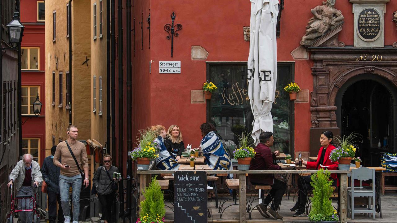 People sit in a restaurant in Stockholm in May when, in much of the rest of the world, people were huddled indoors. Picture: Jonathan NACKSTRAND / AFP