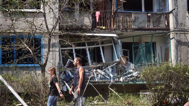 Residents of an apartment complex in Bakhmut begin to remove their belongings after a projectile fired on Sunday night from Russian troops landed in courtyard between two buildings. Picture: Getty Images