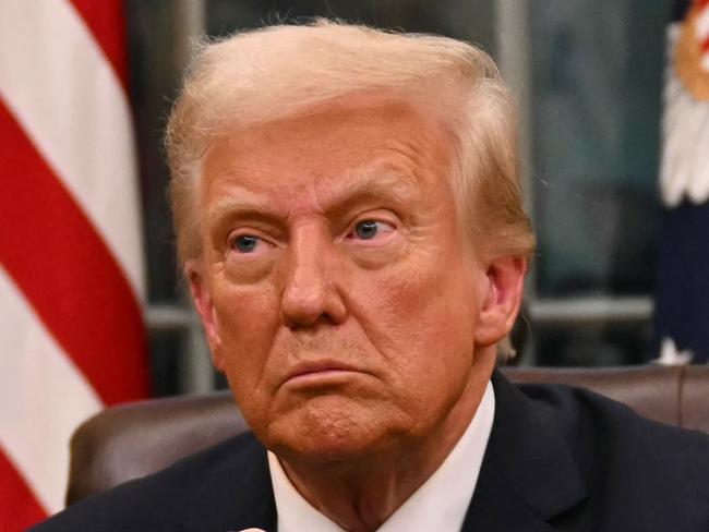 US President Donald Trump holds up outgoing President Joe Biden's letter as he signs executive orders in the Oval Office of the WHite House in Washington, DC, on January 20, 2025. (Photo by Jim WATSON / POOL / AFP) / ALTERNATE CROP