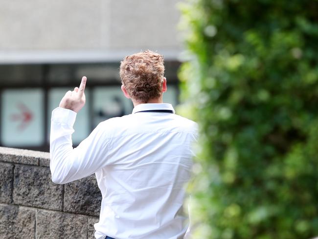 Robert Calamatta gives a newspaper photographer the middle finger after pleading guilty to supplying heroin. (AAP Image/Sue Graham)