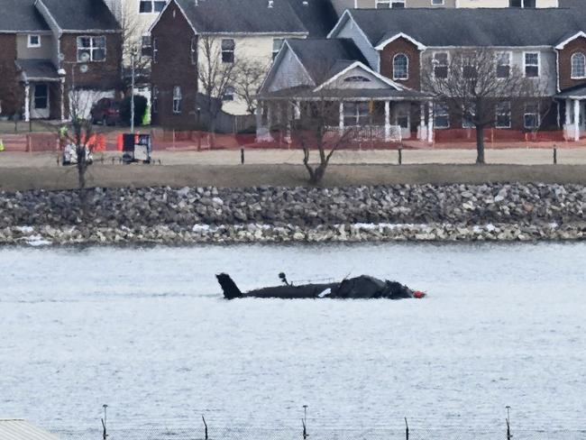 Part of the wreckage is seen along the Potomac River after American Airlines flight 5342 on approach to Reagan National Airport crashed into the river after colliding with a US Army helicopter, near Washington, DC, on January 30, 2025. US President Donald Trump -- speaking as the bodies of 67 people were being pulled from Washington's Potomac River -- launched a political attack January 30, 2025 blaming diversity hires for the midair collision between an airliner and a military helicopter. (Photo by Oliver Contreras / AFP)