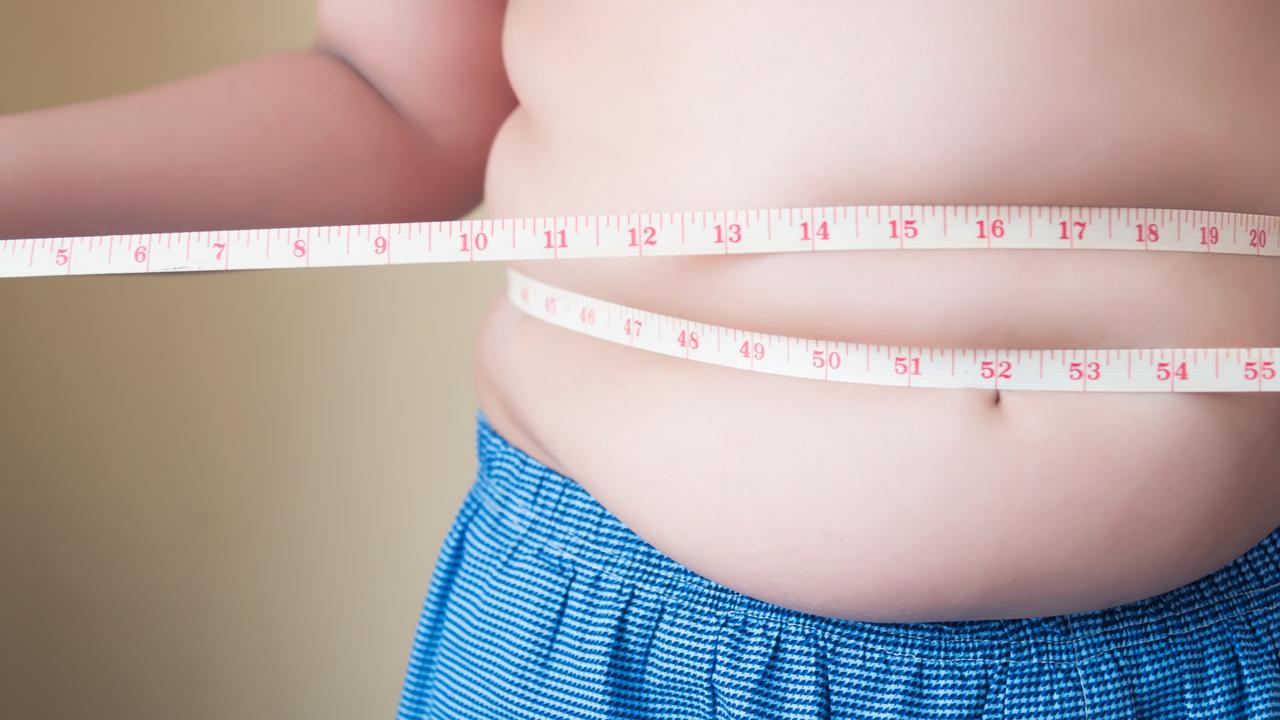 A generic stock image showing an obese or overweight child measuring his weight isolated on white background. Picture: istock
