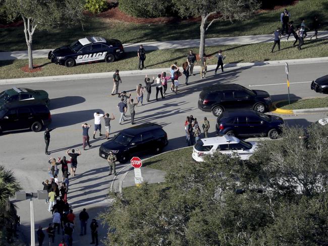 Students hold their hands in the air after being evacuated by police from Marjory Stoneman Douglas High School in Parkland, Florida. Picture: Mike Stocker/South Florida Sun-Sentinel/AP