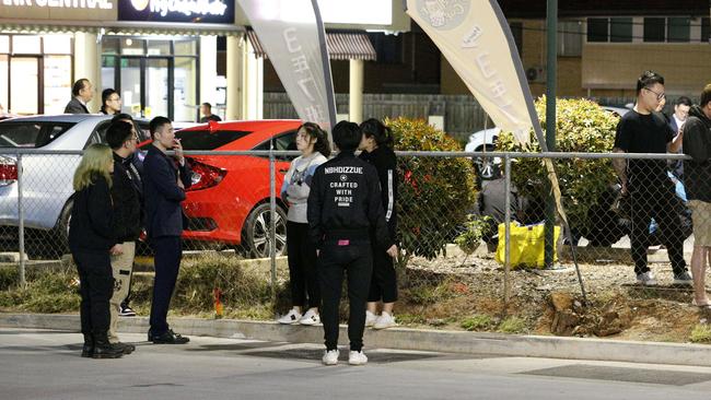 Occupants of nearby businesses watch the drama unfold. Picture: Steve Pohlner