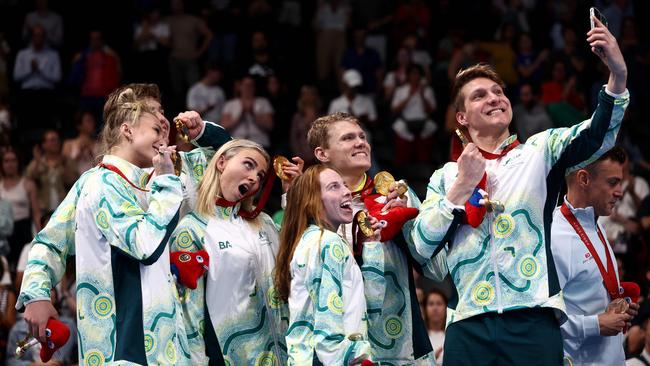 Gold medallist Australia's team swimmers Jesse Aungles, Keira Stephens, Emily Beecroft, Callum Simpson, Timothy Hodge and Alexa Leary pose for selfies as they celebrate during the victory ceremony for the mixed's 4x100m medley relay final event. Picture: Franck Fife/AFP