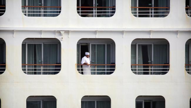 A crew member aboard a stranded cruise ship. Picture: Christian Gilles