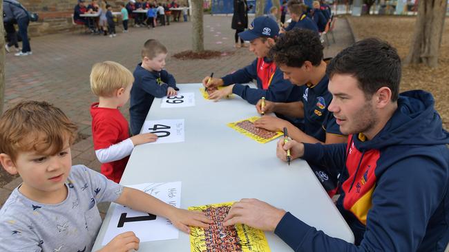 Mitch McGovern of the Crows signs autographs at Goodwood Primary School on Tuesday. Picture: AAP Image/David Mariuz