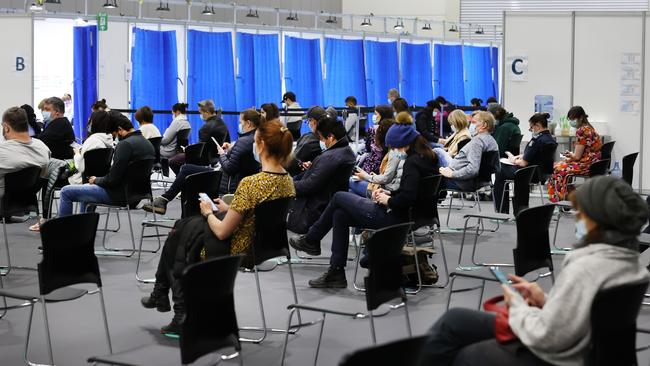 People in the observation area after receiving their vaccination at a hub in the Melbourne Exhibition and Conference Centre. Picture: David Caird