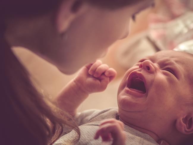 Mother with her newborn baby girl crying