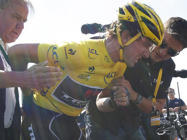 Switzerland's Fabian Cancellara, wearing the overall leader's yellow jersey, is treated for a back injury after crashing.