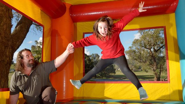 Dixons Creek man Peter Charleton loans out jumping castles for free. Peter and his daughter Chelsea, 7, check out the inside one of his castles.