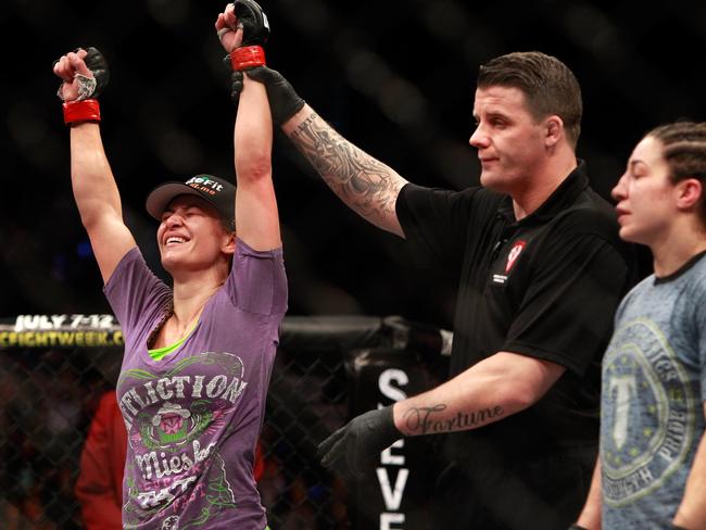 Miesha Tate, left, celebrates a win over Sara McMann.