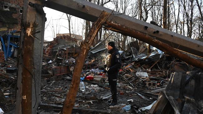 A policeman examines the damage outside an apartment building after the overnight Russian drones attack in Kharkiv. Picture: AFP.