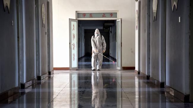 A staff member sprays disinfectant in the compounds of a school as it prepares to reopen in Handan in China's northern Hebei province. Picture: AFP