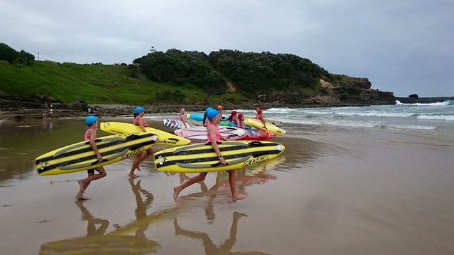 Yamba Surf Lifesaving Club nippers run into the surf during training.