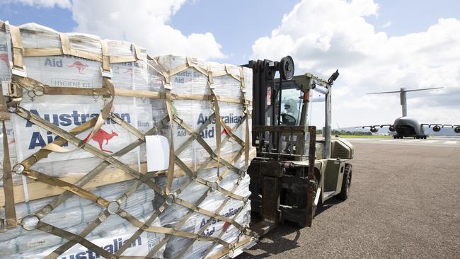 RAAF Leading Aircraftwoman Caddie Morrow transfers a palette of humanitarian aid from a C-17A Globemaster to a holding area at Port Vila airport in Vanuatu.