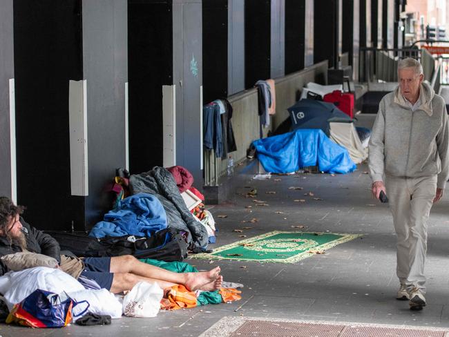 People walk past the the Homeless crisis at Martin Place RBA building. Picture:Thomas Lisson.