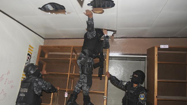 In this 14 Jun 2012 photo, national police inspect a home that had been seized by gangs in the 14 de Marzo neighborhood in Tegucigalpa, Honduras. Gang members seized the home after the rightful owners fled, unable to pay their extortion fees. Extortion of homeowners is a chilling new crime trend in Honduras, already among the world's most dangerous countries. By demanding people pay to stay in their own homes, gang members have emptied some neighborhoods and have changed the way many live. (AP Photo/Fernando Antonio)