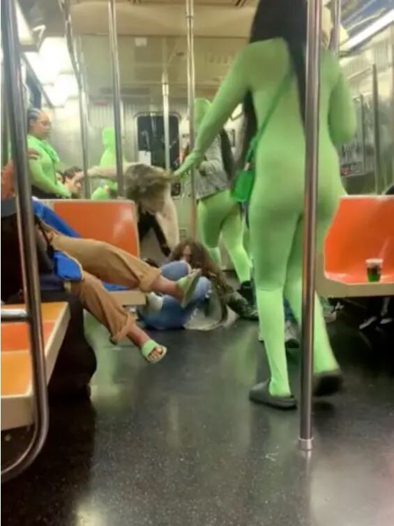 A video filmed on the Subway shows six women dressed in green suits tossing around one of the teens and punching her repeatedly in the face. Picture: Reddit/RoBoyJones