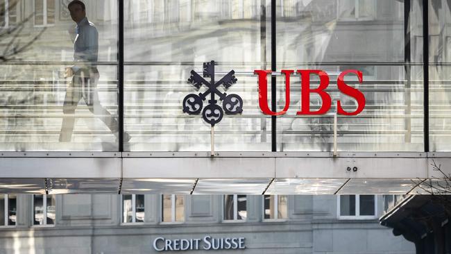 A employee is seen in silhouette with sign of Swiss giant banking UBS and a sign of Credit Suisse bank in Zurich. Picture: Fabrice AFP