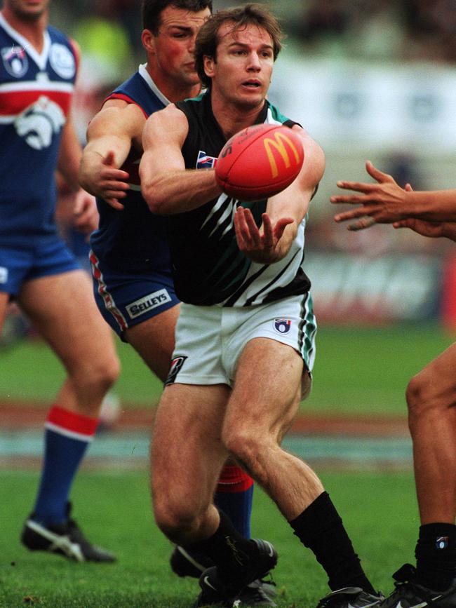 Port Adelaide’s Josh Francou dishes out a handball under pressure from Bulldog Brad Johnson.