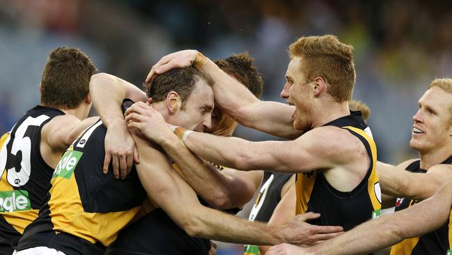 Shane Tuck is mobbed by Richmond teammates after kicking a goal.