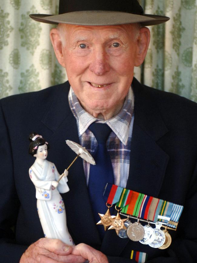 Allan Chick with his medals and a Japanese porcelain doll at home in Heyfield in 2005.