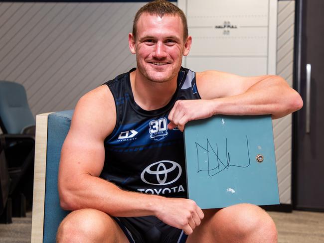 Cowboys player Coen Hess with his signed locker door which will go up for auction as part of the Cowboys Community Foundation;s Christmas Auction.