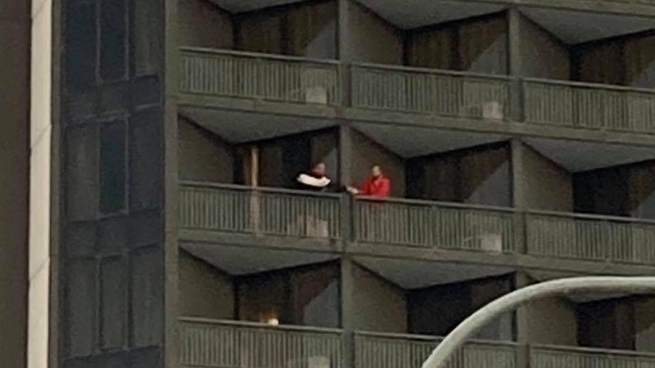 Guests share items between balconies at Brisbane’s Hotel Grand Chancellor on May 25.