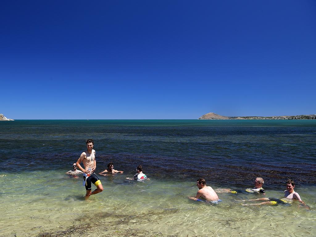 Cyclists cool off in the sea at Victor Harbor after the stage three finish. Picture: Daniel Kalisz/Getty Images