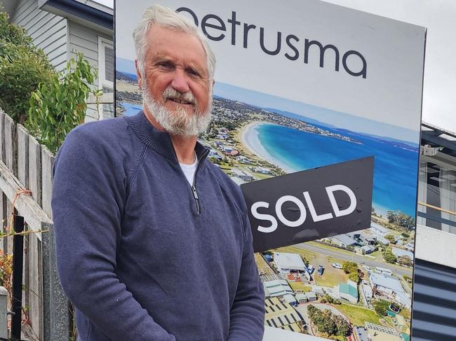 Ivan Cunningham pops the sold sticker on home for sale signage. Picture: Supplied